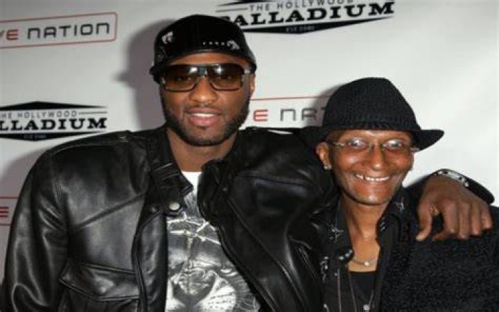 Joe Odom in black hat and jacket with his son in a black cap, goggles, and black leather jacket.