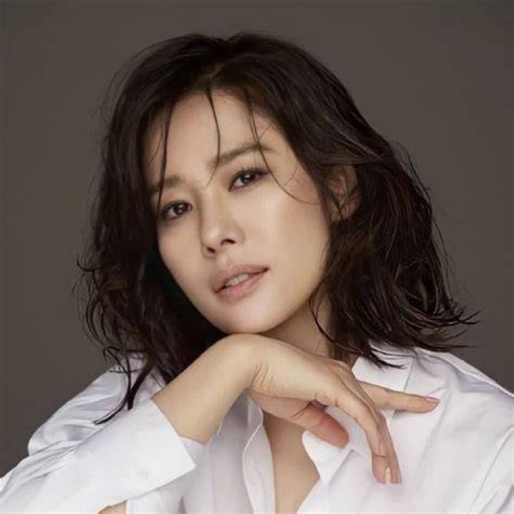 Kim Hyun Joo posing in a white glittering dress.