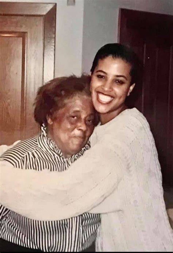 Kimberly Craig in white sweater hugging her grandmother who is wearing a black stripped shirt.